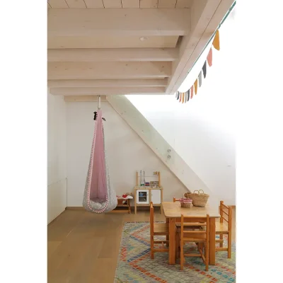 Children's play room in Oasis on Glen with a hanging chair, a small table and chairs and a play kitchenette.