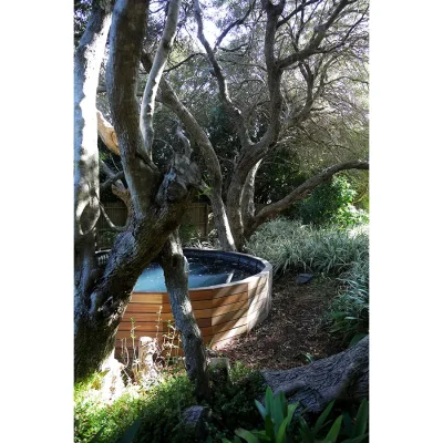 Secluded wooden hot tub situated in the luscious green garden of Pinebeach.