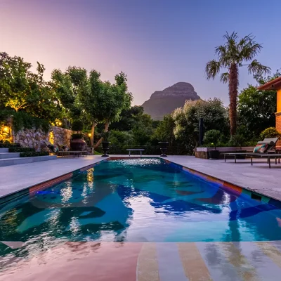 Vibrant coloured pool overlooking tropical garden and views of Signal Hill. House Nouveau.