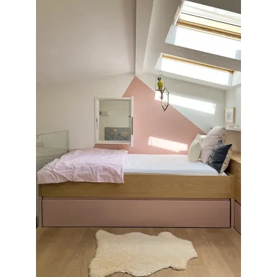 A loft room with pink walls that match the pink bedding on the double bed with two skylights illuminating the space. Oasis On Glen.