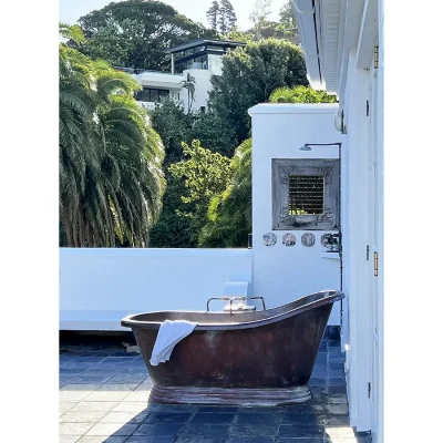 Outdoor brass victorian bath tub on Villa Toscana's large balcony with an outdoor shower.