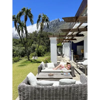 Villa Toscana patio with two wicker sofas and a light wooden coffee table with expansive views of the garden and Table Mountain in the background.